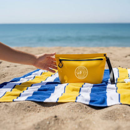 Yellow waterproof pouch on beach towel